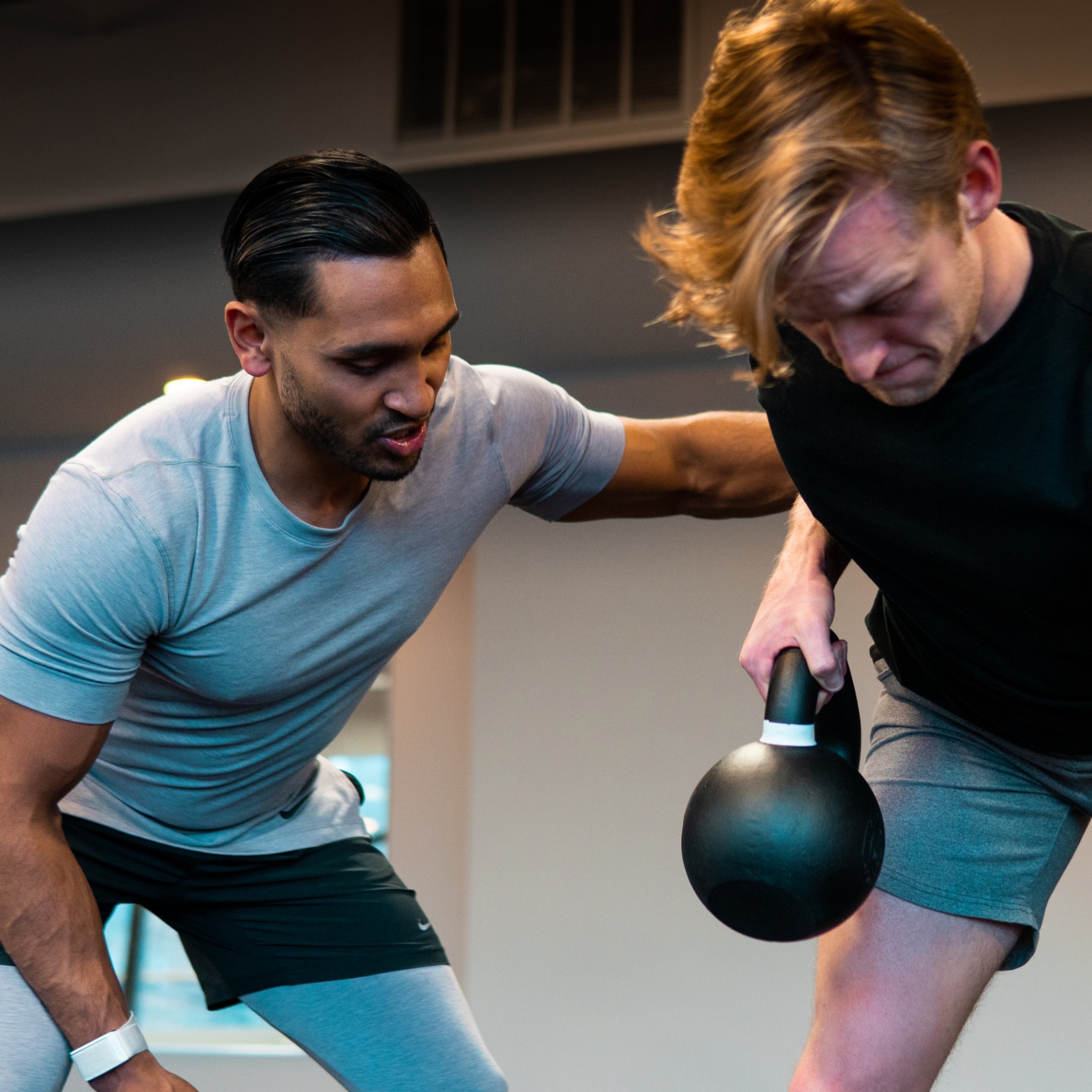 FENIX coach guiding a participant through a kettlebell event